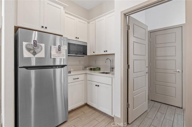 1938 N Frontier St, Hanford, CA 93230 - kitchen featuring stainless steel appliances, white cabinets, light countertops, and light wood finished floors
