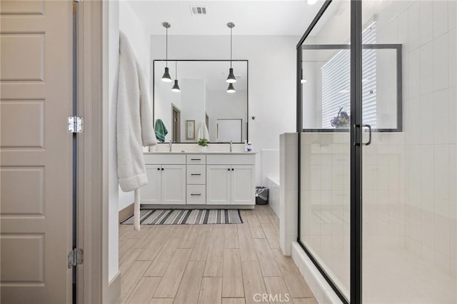 1938 N Frontier St, Hanford, CA 93230 - bathroom with double vanity, a shower stall, a bath, and wood finished floors