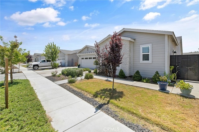 1938 N Frontier St, Hanford, CA 93230 - view of front of home with concrete driveway, a garage, brick siding, and a residential view