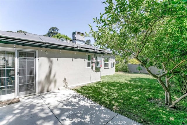11063 White Oak Ave, Granada Hills, CA 91344 - view of side of property featuring stucco siding, a yard, solar panels, and a patio area