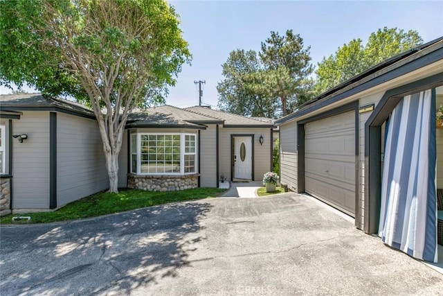 11063 White Oak Ave, Granada Hills, CA 91344 - ranch-style house featuring driveway, a garage, and stone siding