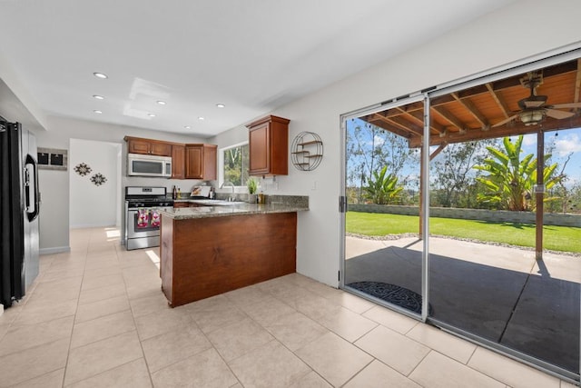 1161 Senwood Way, Fallbrook, CA 92028 - kitchen with gas range, a peninsula, a ceiling fan, black fridge, and light tile patterned flooring