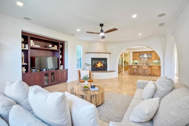 14317 Salida Del Sol, San Diego, CA 92127 - living room featuring arched walkways, a ceiling fan, ornamental molding, recessed lighting, and a large fireplace