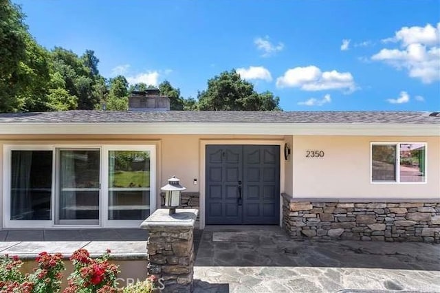 2350 Oak Park Rd, Glendora, CA 91741 - entrance to property featuring driveway, stucco siding, stone siding, an attached garage, and a chimney