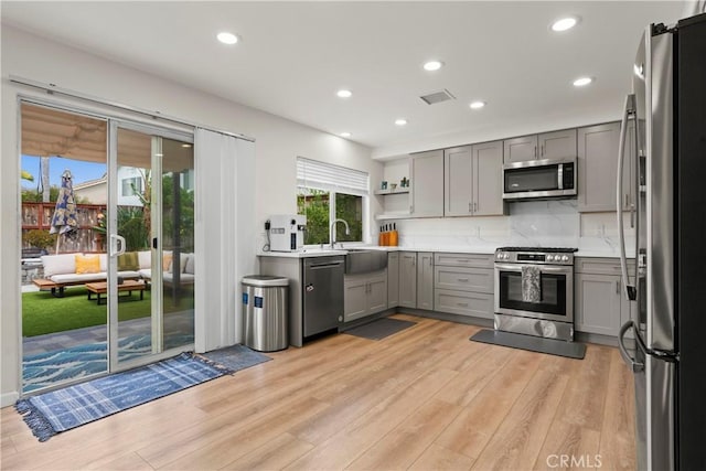 401 Lupine Way, Oceanside, CA 92057 - kitchen with stainless steel appliances, gray cabinetry, light wood-style floors, open shelves, and light countertops
