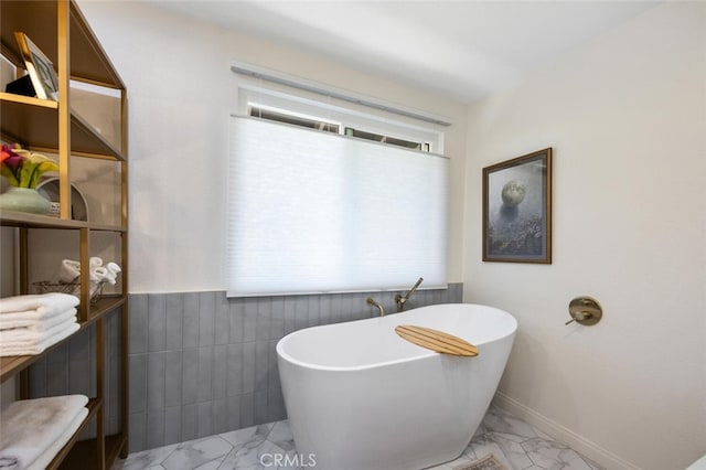 1579 Via Parque, Thousand Oaks, CA 91360 - bathroom featuring marble look tiles, a freestanding bath, a wainscoted wall, and tile walls