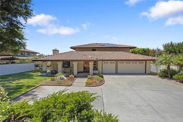1579 Via Parque, Thousand Oaks, CA 91360 - mediterranean / spanish house with a chimney, an attached garage, concrete driveway, roof mounted solar panels, and a tiled roof