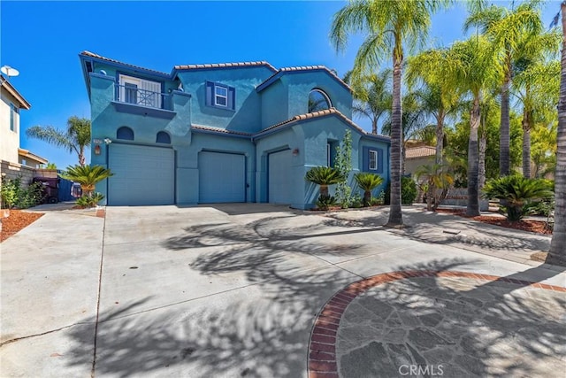 32522 Safflower St, Winchester, CA 92596 - mediterranean / spanish-style house featuring a balcony, a garage, concrete driveway, stucco siding, and a tile roof