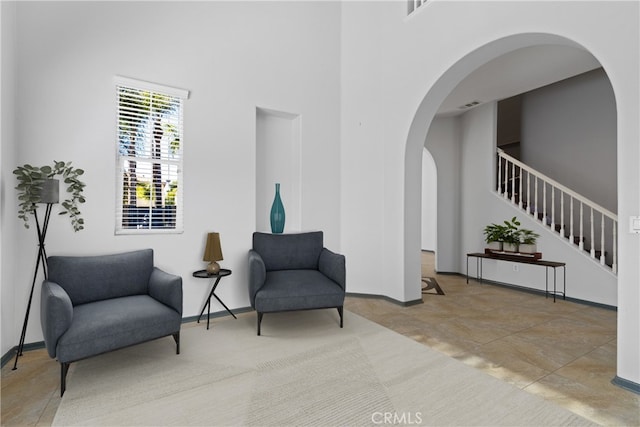32522 Safflower St, Winchester, CA 92596 - living area featuring arched walkways, stairway, and a high ceiling
