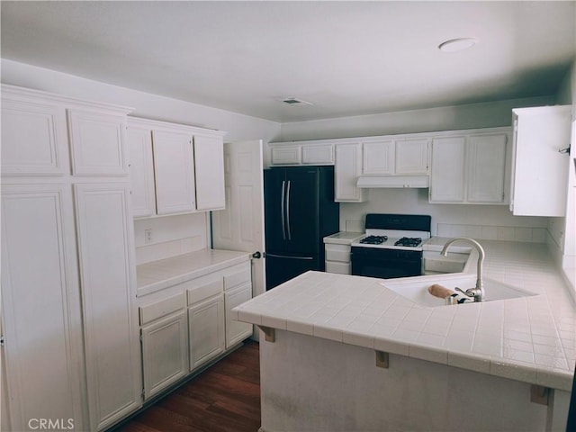 38644 Palms Pl, Palmdale, CA 93552 - kitchen featuring gas stove, freestanding refrigerator, white cabinetry, dark wood-style flooring, and tile counters