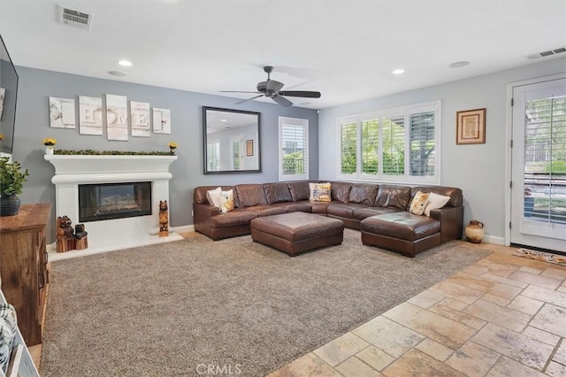 29160 Harmony Way, Saugus, CA 91390 - living room featuring plenty of natural light, recessed lighting, ceiling fan, a glass covered fireplace, and stone tile floors