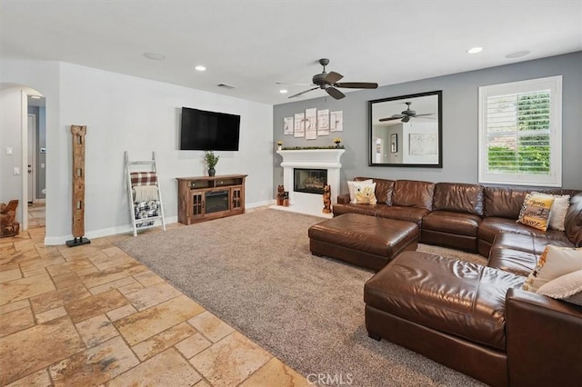 29160 Harmony Way, Saugus, CA 91390 - living area with arched walkways, a ceiling fan, stone tile flooring, recessed lighting, and a glass covered fireplace