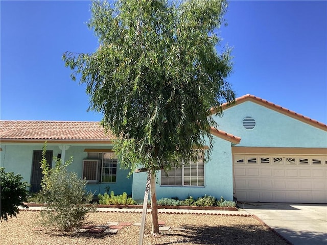 13489 Buggy Whip Ct, Victorville, CA 92392 - mediterranean / spanish house with a tiled roof, stucco siding, concrete driveway, and a garage