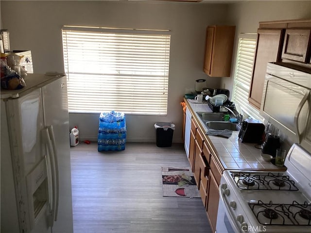 13489 Buggy Whip Ct, Victorville, CA 92392 - kitchen with tile countertops, white appliances, wood finished floors, and plenty of natural light