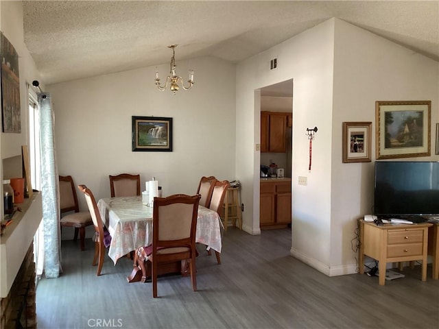 13489 Buggy Whip Ct, Victorville, CA 92392 - dining area featuring wood finished floors, vaulted ceiling, and a chandelier