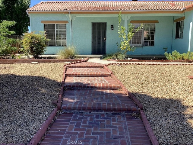 13489 Buggy Whip Ct, Victorville, CA 92392 - view of exterior entry featuring a tile roof and stucco siding