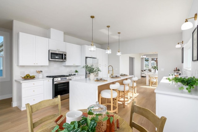 7284 W Point Ave, La Mesa, CA 91942 - kitchen with stainless steel appliances, light wood finished floors, white cabinets, and light countertops