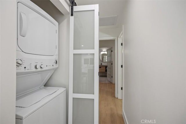 3253 San Amadeo Unit P, Laguna Woods, CA 92637 - washroom with stacked washer / dryer and light wood-style floors