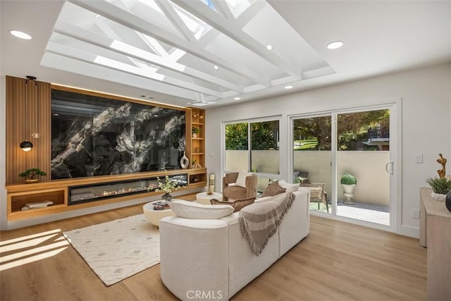 3253 San Amadeo Unit P, Laguna Woods, CA 92637 - cinema featuring light wood finished floors, recessed lighting, a skylight, a glass covered fireplace, and beam ceiling