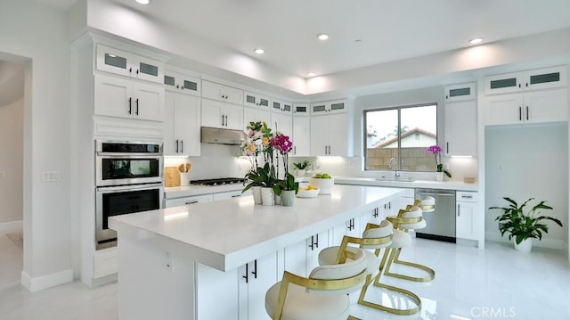 17413 Siena Ln, Fountain Valley, CA 92708 - kitchen with stainless steel appliances, a center island, white cabinetry, light countertops, and recessed lighting