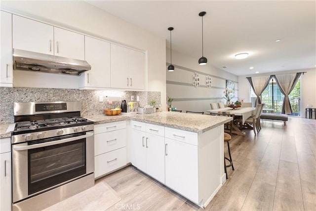 9044 Garvey Ave Unit 21, Rosemead, CA 91770 - kitchen with stainless steel gas range oven, under cabinet range hood, a peninsula, decorative backsplash, and light wood-style floors