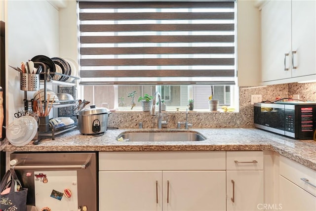 9044 Garvey Ave Unit 21, Rosemead, CA 91770 - kitchen featuring stainless steel microwave, white cabinetry, decorative backsplash, and light stone counters