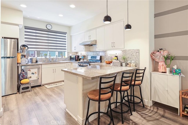 9044 Garvey Ave Unit 21, Rosemead, CA 91770 - kitchen featuring appliances with stainless steel finishes, a peninsula, light wood-style floors, white cabinetry, and tasteful backsplash