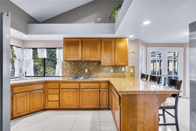 1549 Hillcrest Dr, Pomona, CA 91768 - kitchen with a peninsula, a breakfast bar area, brown cabinets, decorative backsplash, and recessed lighting