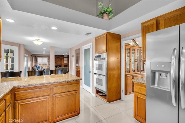 1549 Hillcrest Dr, Pomona, CA 91768 - kitchen with stainless steel appliances, light stone counters, recessed lighting, light tile patterned flooring, and brown cabinetry