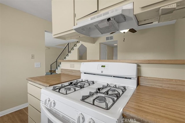 675 S College Ave, Claremont, CA 91711 - kitchen with white range with gas cooktop, under cabinet range hood, ceiling fan, wood finished floors, and butcher block counters