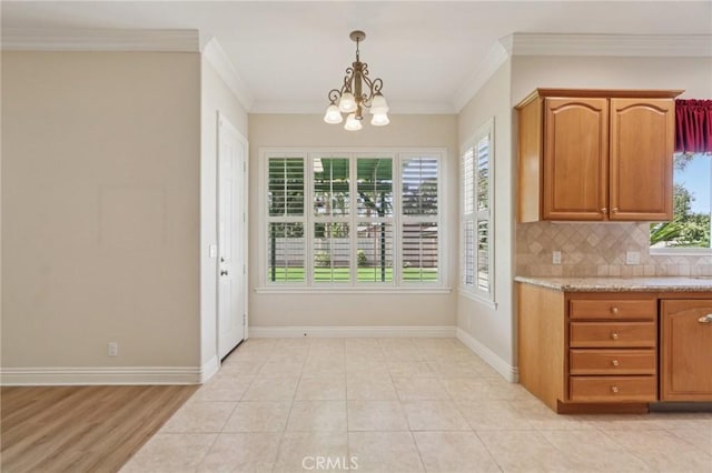 16860 Rayen St, Northridge, CA 91343 - kitchen featuring a chandelier, backsplash, crown molding, hanging light fixtures, and brown cabinetry