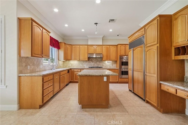 16860 Rayen St, Northridge, CA 91343 - kitchen featuring under cabinet range hood, crown molding, paneled fridge, a center island, and light stone counters