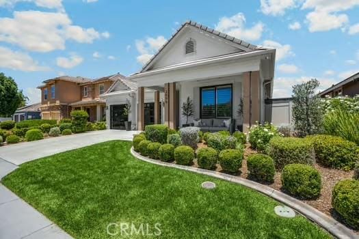 2056 Caltha Way, Perris, CA 92571 - view of front of property with a front lawn, concrete driveway, a porch, and stucco siding