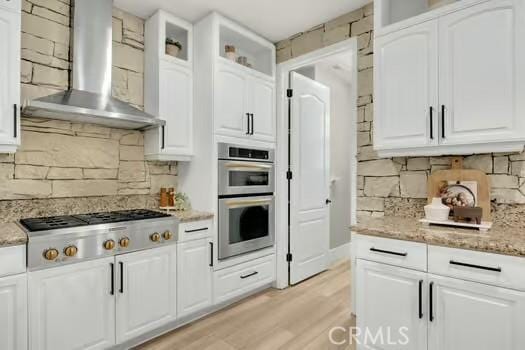 2056 Caltha Way, Perris, CA 92571 - kitchen featuring wall chimney exhaust hood, appliances with stainless steel finishes, backsplash, and white cabinets