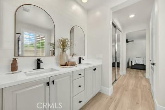 2056 Caltha Way, Perris, CA 92571 - bathroom featuring wood finished floors, double vanity, ensuite bath, and recessed lighting