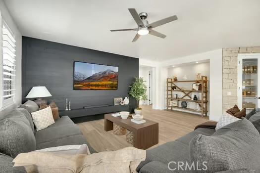 2056 Caltha Way, Perris, CA 92571 - living area featuring an accent wall, a ceiling fan, and wood finished floors