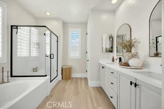 2056 Caltha Way, Perris, CA 92571 - full bathroom with a stall shower, a bath, wood finished floors, double vanity, and recessed lighting