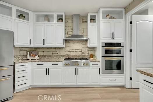 2056 Caltha Way, Perris, CA 92571 - kitchen with appliances with stainless steel finishes, wall chimney exhaust hood, light stone counters, and white cabinets