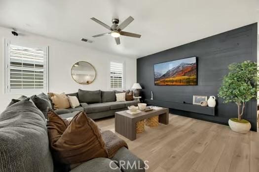 2056 Caltha Way, Perris, CA 92571 - living room featuring light wood-style floors, ceiling fan, and an accent wall