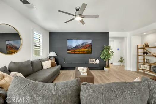 2056 Caltha Way, Perris, CA 92571 - living area with wood finished floors, ceiling fan, and an accent wall