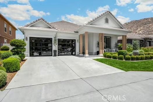 2056 Caltha Way, Perris, CA 92571 - view of front facade featuring an attached garage, concrete driveway, a porch, a mountain view, and a tile roof