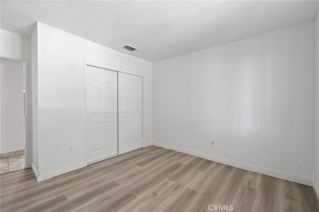 921 Christian Ave, Bakersfield, CA 93314 - unfurnished bedroom featuring wood finished floors, a closet, and a textured ceiling