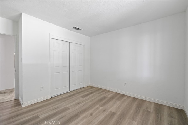 921 Christian Ave, Bakersfield, CA 93314 - unfurnished bedroom featuring wood finished floors, a closet, and a textured ceiling