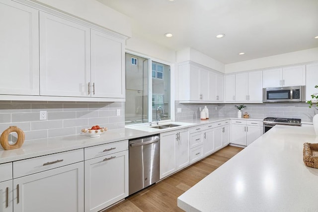 6140 Colt Pl Unit 104, Carlsbad, CA 92009 - kitchen with stainless steel appliances, white cabinetry, light countertops, backsplash, and recessed lighting