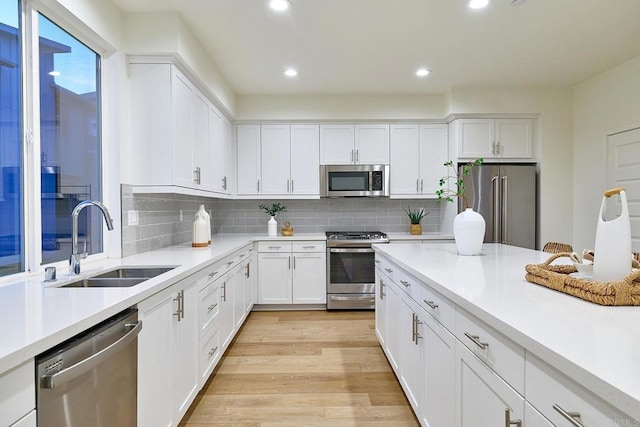 6140 Colt Pl Unit 104, Carlsbad, CA 92009 - kitchen with appliances with stainless steel finishes, light countertops, white cabinets, tasteful backsplash, and recessed lighting