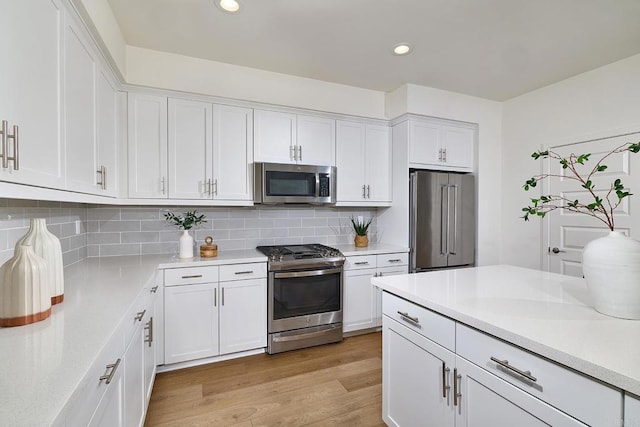 6140 Colt Pl Unit 104, Carlsbad, CA 92009 - kitchen featuring appliances with stainless steel finishes, white cabinets, light countertops, backsplash, and recessed lighting