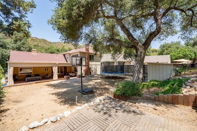2248 E Chevy Chase Dr, Glendale, CA 91206 - back of house with a trampoline, a patio area, and a chimney