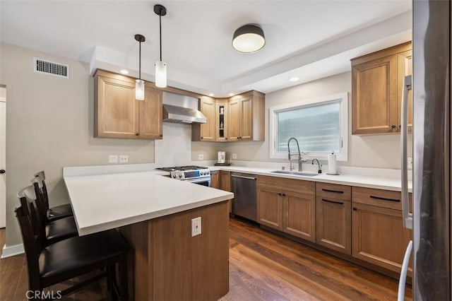 2248 E Chevy Chase Dr, Glendale, CA 91206 - kitchen with appliances with stainless steel finishes, wall chimney range hood, a peninsula, dark wood-style floors, and a kitchen breakfast bar