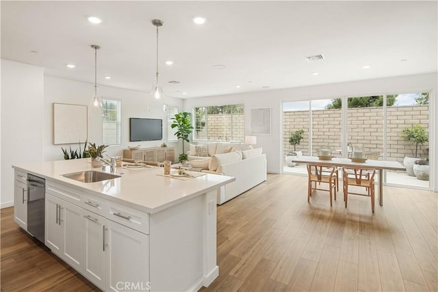 4830 Arroyo Run, Moorpark, CA 93021 - kitchen with dishwasher, open floor plan, an island with sink, light countertops, and white cabinetry