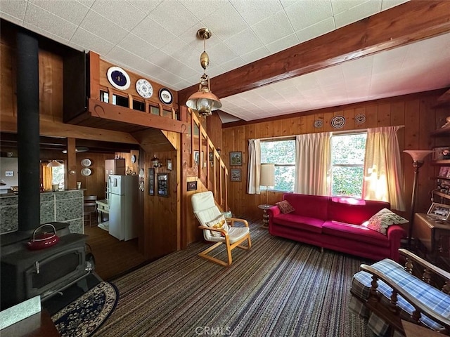 41132 Oak Dr, Forest Falls, CA 92339 - living room featuring wooden walls, carpet, a wood stove, beamed ceiling, and stairs